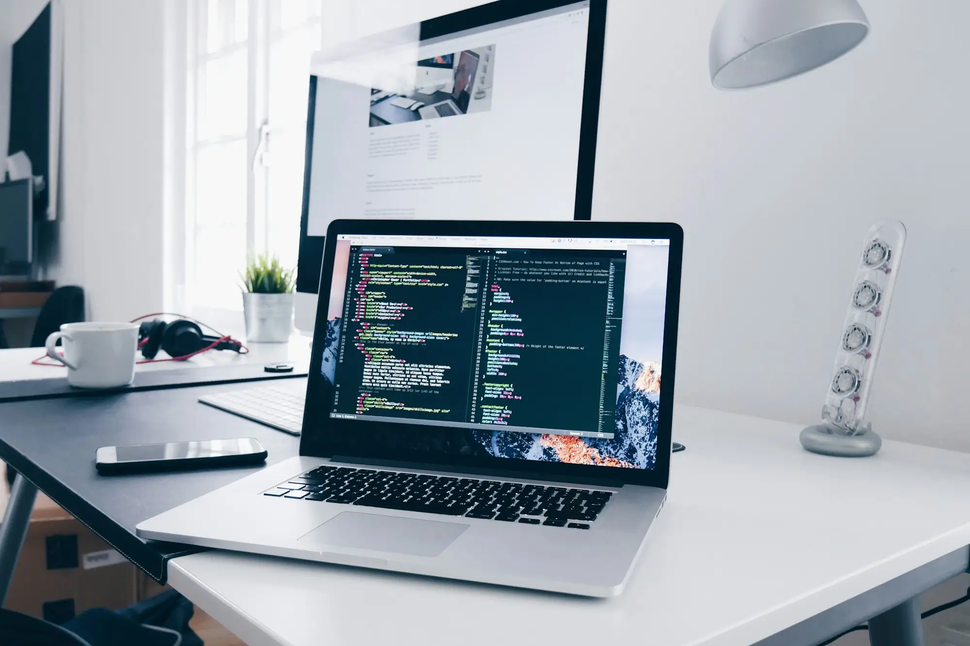 Laptop showing code on a bright desk