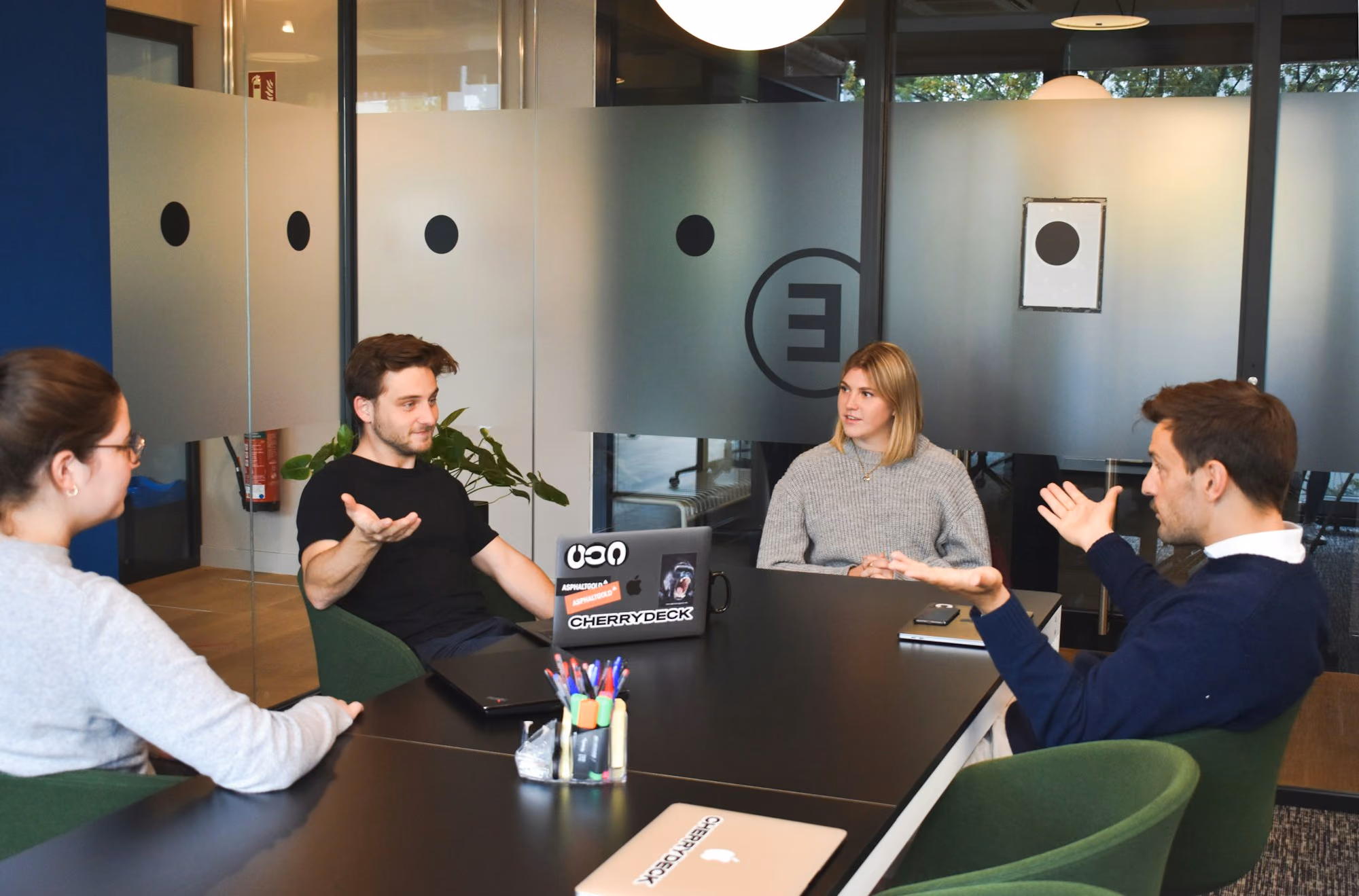 Four people in conversation at a meeting table