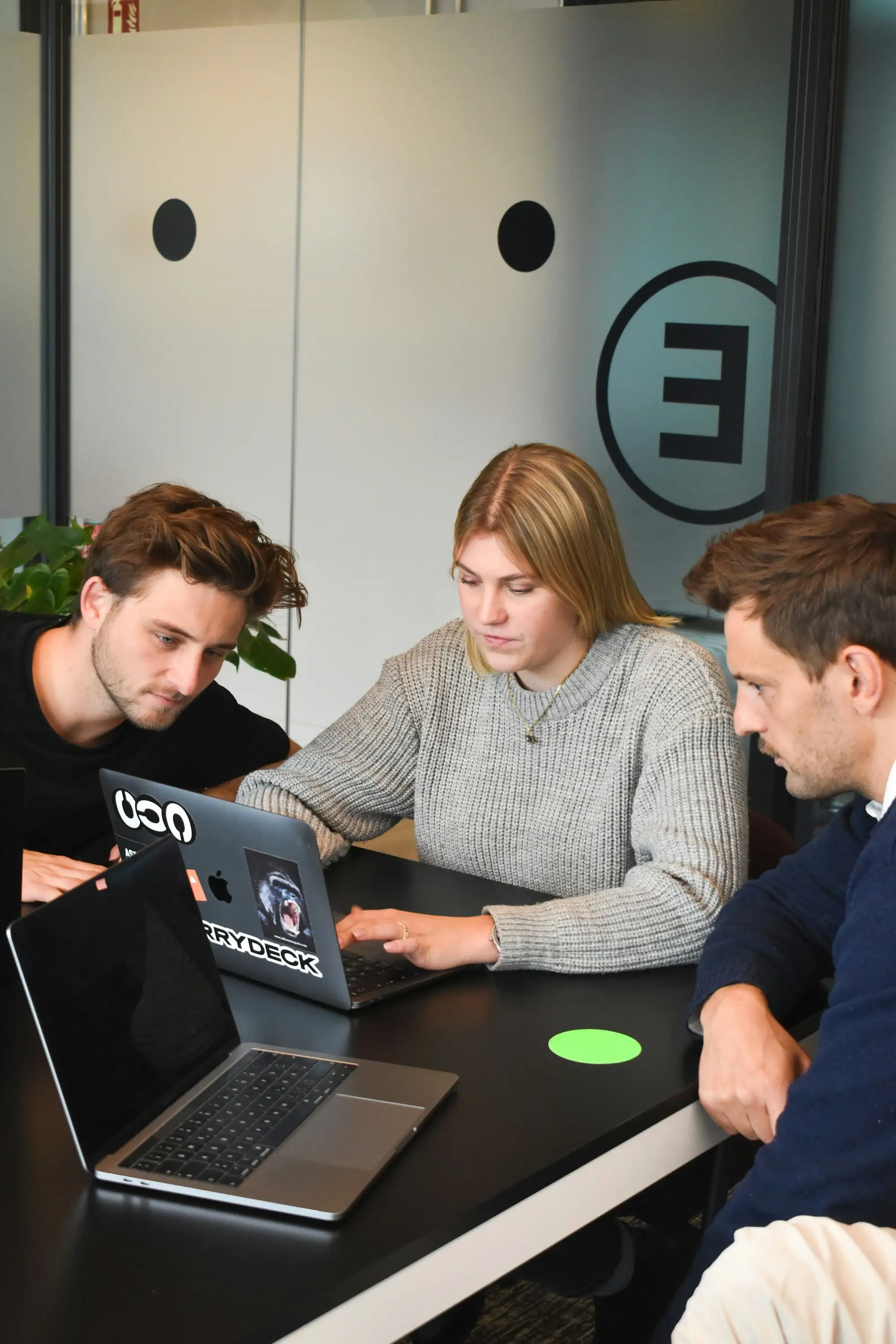 Three people working together on a laptop