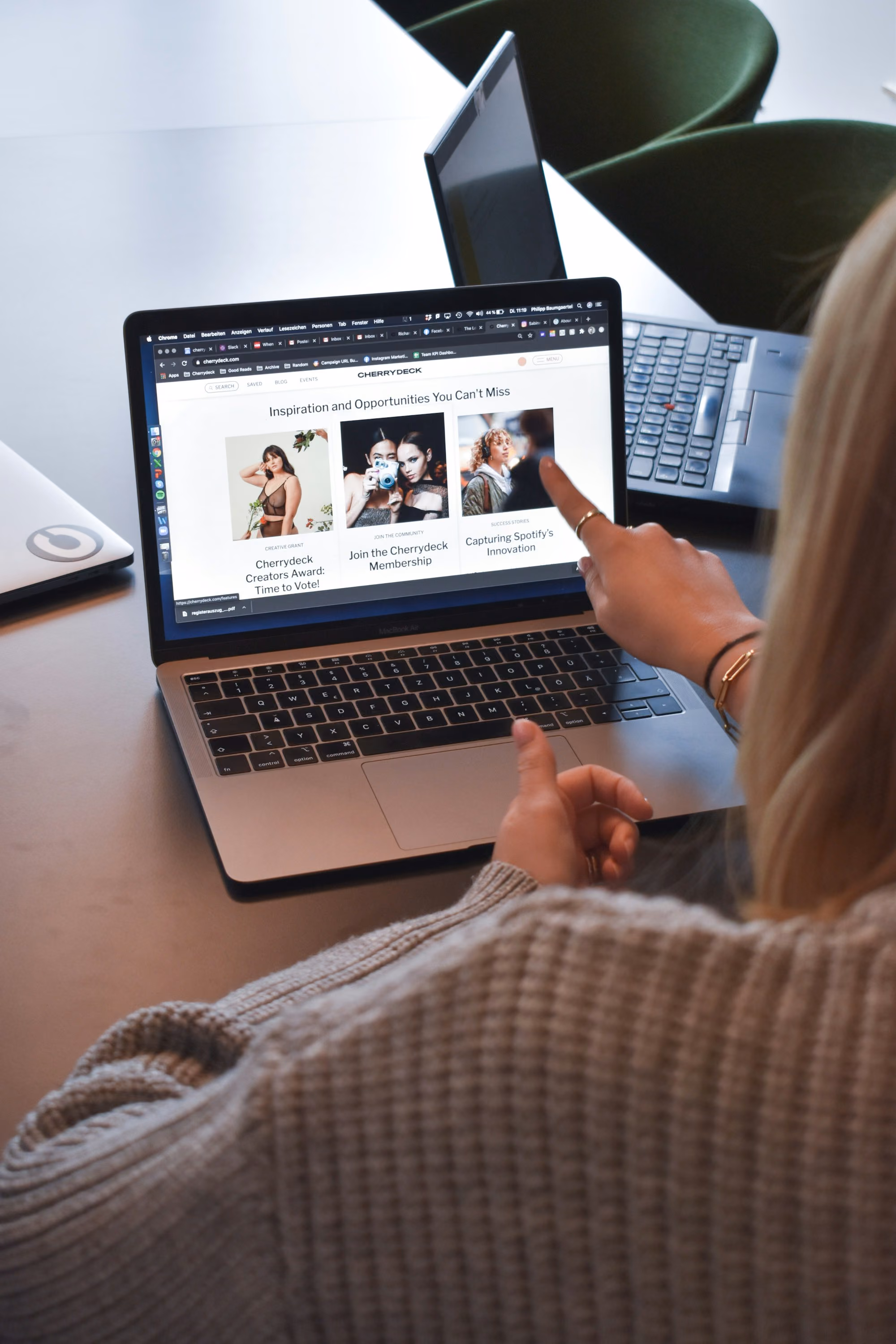 Une main touche un site web sur l’écran d’un ordinateur portable